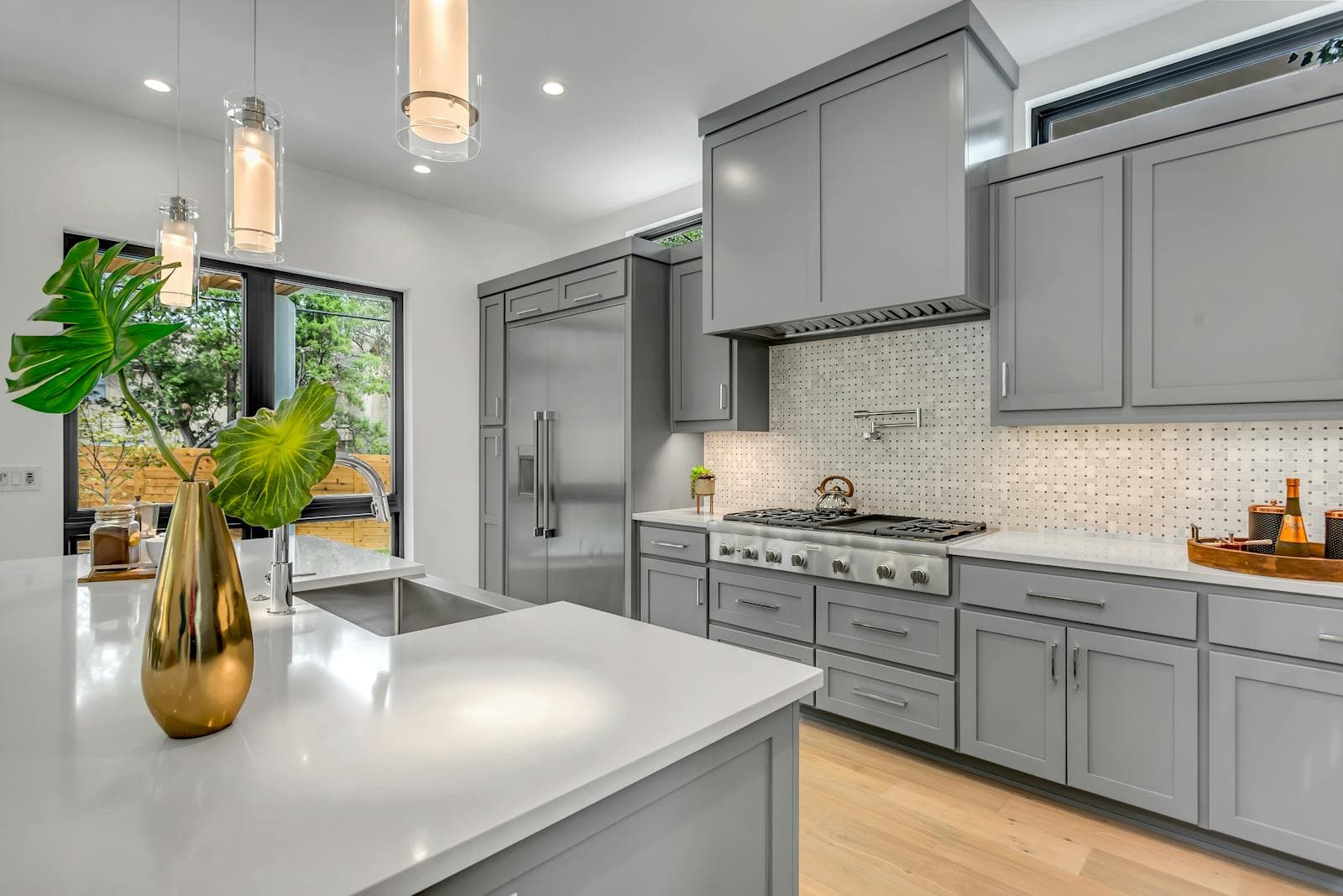 Renovated modern kitchen with gray cabinetry and pendant lighting